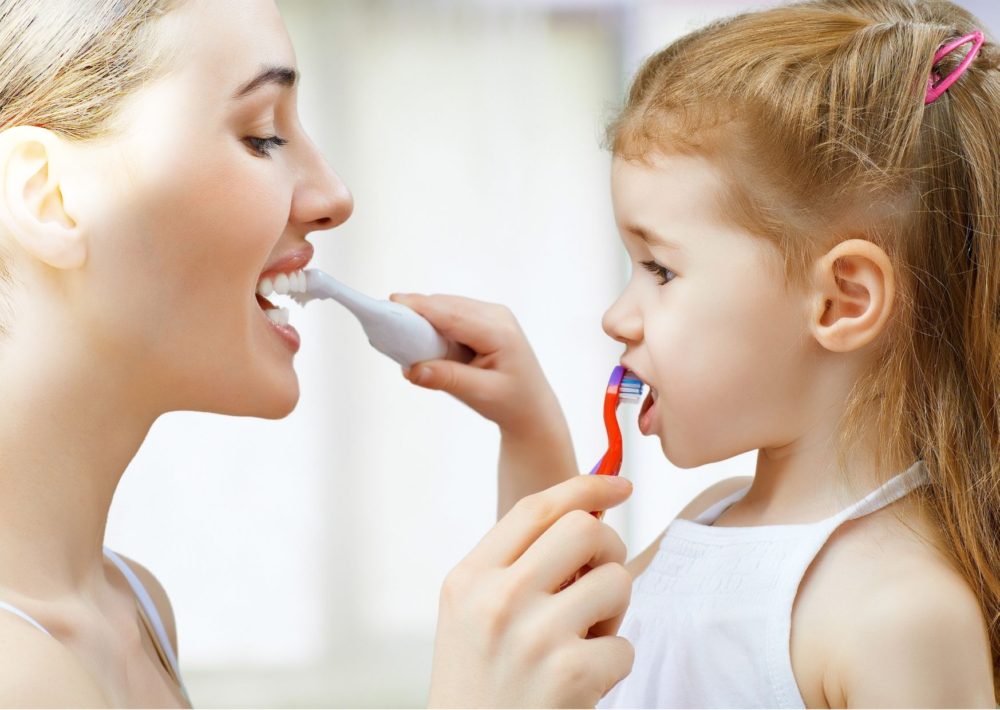 Children Dental Care - mom and daughter brushing teeth