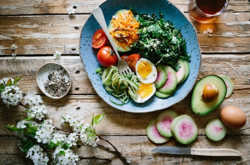 A colorful nourishing bowl with fresh vegetables, eggs, and avocado